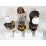 A small brass oil lamp, two further oil lamps and four additional miniature glass shades.