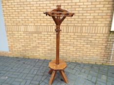 A good quality solid oak hall stand with revolving coat hooks and lower gallery seated area,