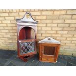 Two wall hanging corner cabinets, one with astral glazed glass door.