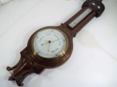 A carved oak wheel barometer / thermometer, 89 cm (high) - This lot MUST be paid for and collected,