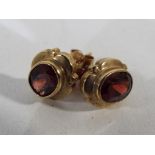 A pair of 9 carat gold garnet solitaire stud earrings - This lot MUST be paid for and collected,