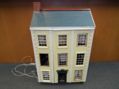 Dolls House - A three storey furnished dolls house of wooden construction, with a mix of wooden,