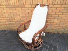 A cane swivel rocking chair - This lot MUST be paid for and collected, or delivery arranged,