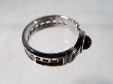 A silver Charles Rennie Mackintosh ring with black stone.