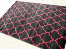A modern rug in black and burgundy,