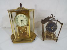 Two revolving ball clocks, one with Roma