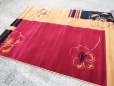 A red, black and tan modern rug, approx