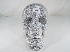 A silvered head in the style of a Skull,