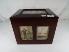 A mahogany storage box with photo panels