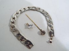 A gentleman's white metal diamond cut curb bracelet marked PL 18k, a stone set yellow metal tiepin,