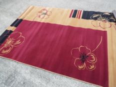 A red, black and tan modern rug, approx