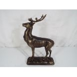 A cast bronzed figure of a deer on a plinth, approximate height 30 cm x 19 cm, boxed.