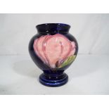 Moorcroft Pottery - a small Moorcroft Pottery vase in the form of an urn decorated in the Magnolia