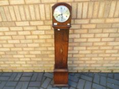 A good quality oak cased grandmother clock Roman numerals to a silvered dial,