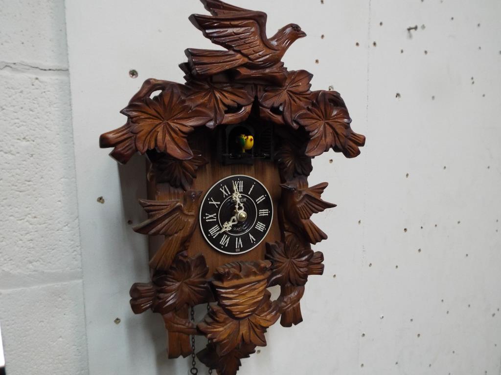 A carved wooden case wall mounted cuckoo clock by Kaiser,