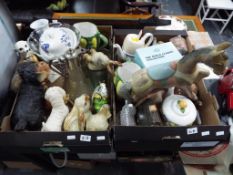 Two boxes containing a quantity of good quality figurines, fireside dog, water jugs, glassware,