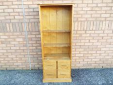 A modern lightwood open bookcase over four drawers by Next approx 160cm x 60cm x 32cm Est £30 - £50