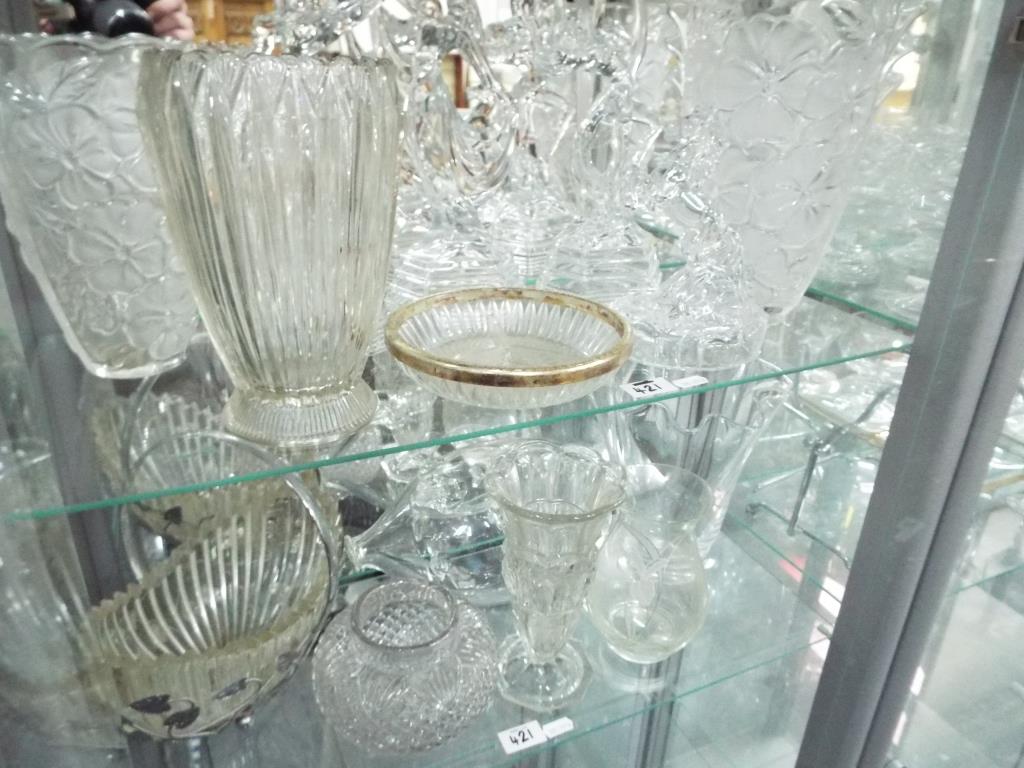 Two shelves containing a quantity of glassware comprising vases, bowls,