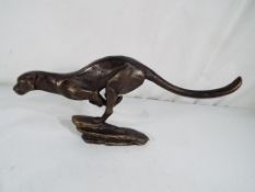 A cast bronzed figurine of a cheetah running, 14 cm x 30 cm.