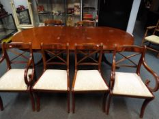An extending dining table with six dining chairs two of which are carvers,