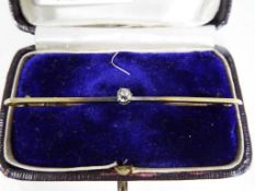A 15 carat gold bar brooch set with solitaire diamond in case, approx weight 2.