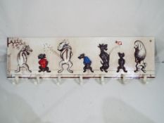 A novelty cast iron coat/cup rack depicting dogs,
