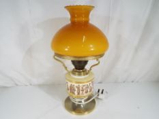 A good quality table lamp decorated with figures in classical dress with amber coloured glass shade,