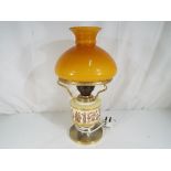 A good quality table lamp decorated with figures in classical dress with amber coloured glass shade,