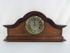A mahogany cased mantel clock with inlaid decoration, Roman numerals to a silvered dial,