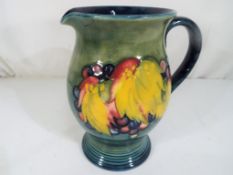 Moorcroft Pottery - A large Moorcroft Pottery single handled jug in the leaf and berry pattern on a