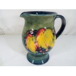 Moorcroft Pottery - A large Moorcroft Pottery single handled jug in the leaf and berry pattern on a