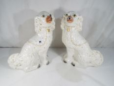 A pair of Staffordshire Pottery fireside figures depicting dogs,