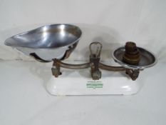 A set of kitchen scales by Berry and Warmington with enamelled base and weights.