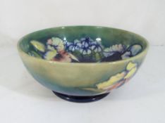 Moorcroft Pottery - A large footed bowl in the "Orchids" pattern on a green ground,
