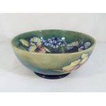 Moorcroft Pottery - A large footed bowl in the "Orchids" pattern on a green ground,