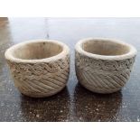 Two circular stone planters decorated with a floral band,