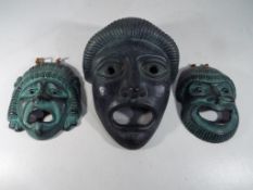 Three Terracotta painted wall masks, largest 22 cm x 17 cm.