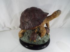 A sculpture depicting a Turtle family mounted on an ebonized plinth, approx.