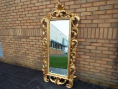 An ornate gilded French wall mirror,