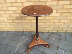 A mahogany bedside table with tripod support claw feet, approximate height 75 cm.