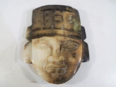 A carved jade stone wall plaque depicting a Mayan figure, 17.5 cm x 13.