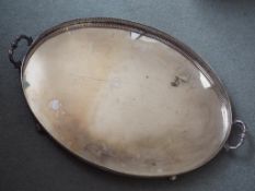 A large plated twin-handled serving tray, the gallery with pierced detail, raised on bun feet,