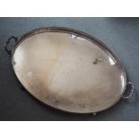 A large plated twin-handled serving tray, the gallery with pierced detail, raised on bun feet,