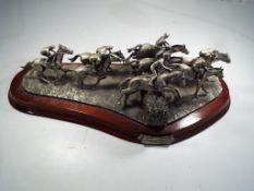 A Craftman's Studio Model figurine depicting horse racing on a wooden plinth entitled National Hunt,