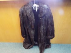 A good quality fur coat by Simpsons, dark brown with slip pockets, approximately 108 cm (l).