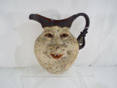 An Israeli ceramic jug decorated with grotesque face,