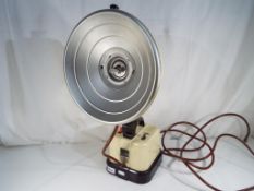 A vintage Hanovia portable ultra - violet ray lamp with cream and brown base.