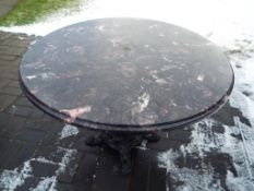A faux marble top table on cast iron supports approx 72cm x 96cm (diam) Est £30 - £50