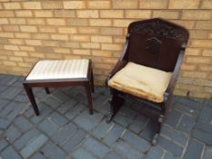 An oak carved hall chair with high ornate back and an upholstered foot stool