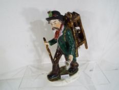 A good quality early 20th century German ceramic figurine depicting a travelling knife sharpener